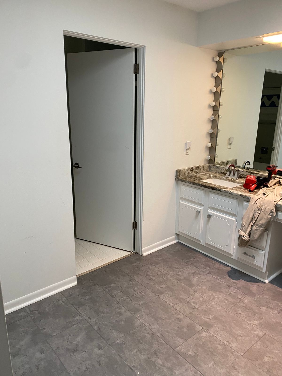 Original vanity with marble counter and Hollywood lights before renovation