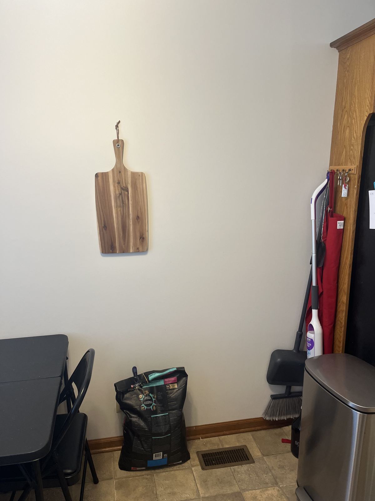 Empty kitchen corner with bare wall, dated vinyl tile floor, and oak trim before the pantry wall was built
