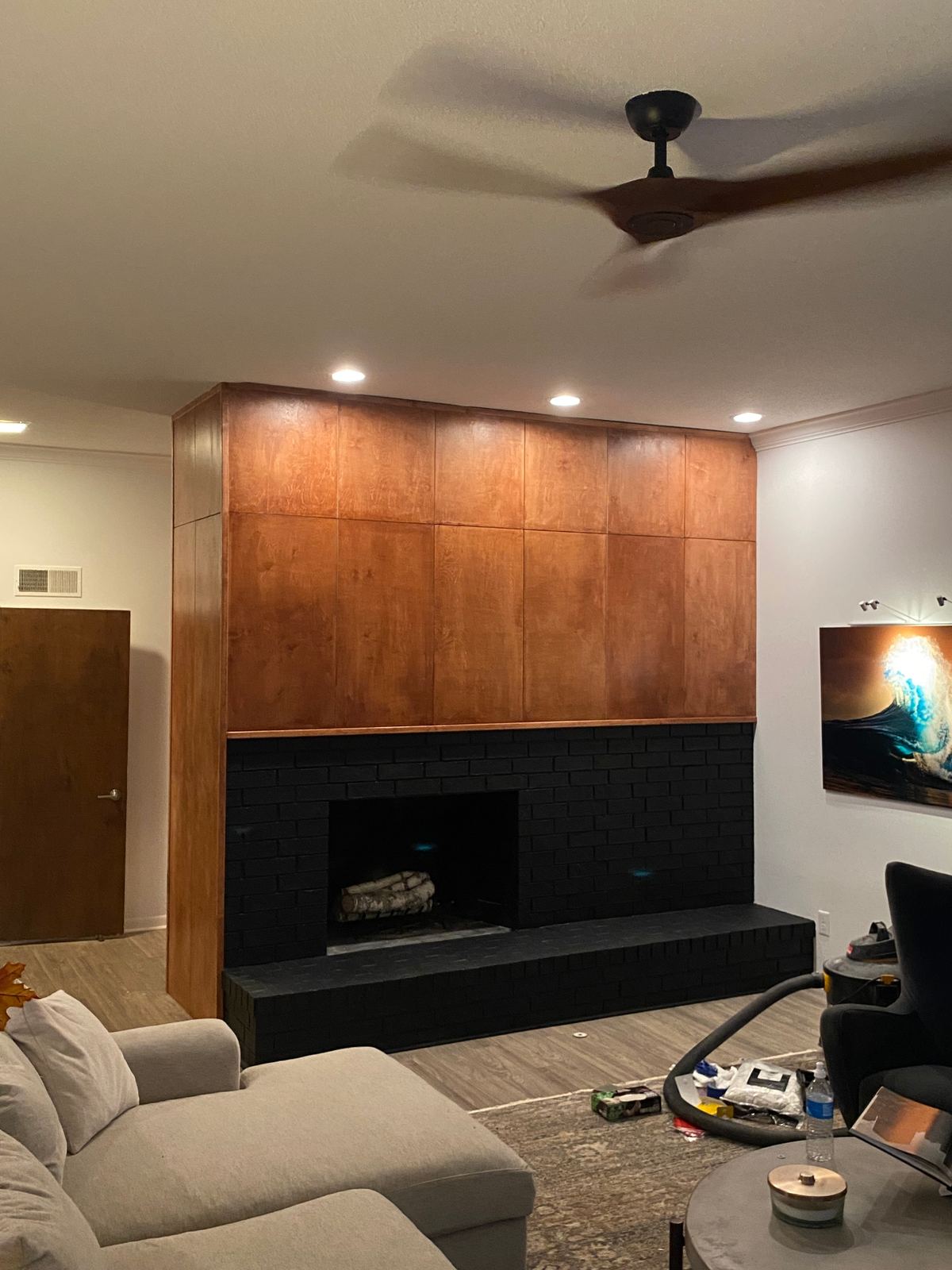 Fireplace feature wall mid-build with framing and unfinished brick before completion